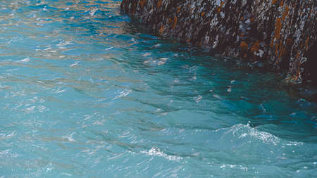 Rock on shore of blue sea. Turquoise mountain lake, the surface of riverの写真素材