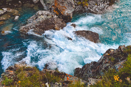 Rough river flow. The blue water of mountain river, the tide on sea with turquoise water and stone banksの写真素材