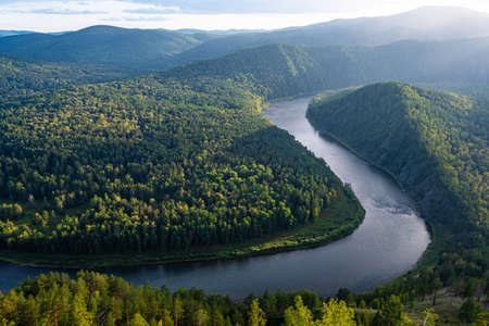 wide river between green hills, smooth bend of riverbed, contemplation of nature for meditation and relaxationの写真素材