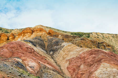 Colored hills in mountain valley. Dry sandy red hills on hot summer day. Drought, climate change. Soil erosion in ravinesの写真素材