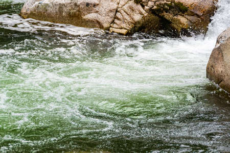 rocky bed of river, fast mountain stream with roiling stream. journey to nature in water valleyの写真素材