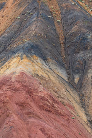 Colored hills, stripes of different colors on slope of canyon. Dry land due to lack of water. Drought in desert. Soil erosionの写真素材