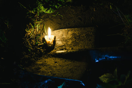 dirty old shovel in dark trench. Digging grave by candlelight. Mystical night sceneの写真素材