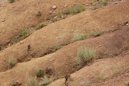Rocks in canyon of dry river bed. Drought due to climate change. Soil erosion of hills. Red sand in mountainsの写真素材