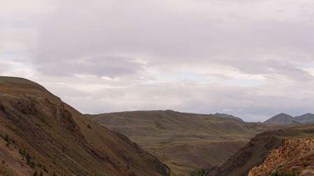 gentle red hills, journey through mountain valley, pastures for animals, soil erosion in arid steppeの写真素材