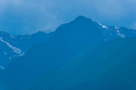 high cliffs in blue haze, silhouette of mountain range in fog, meditation and relaxation in nature
