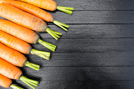 fresh carrots on wooden table after harvesting, cooking for vegetarians, healthy food. Growing...
