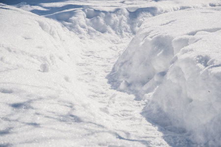 Winter trail in snow among deep snowdrifts. Hiking after snowfall.
