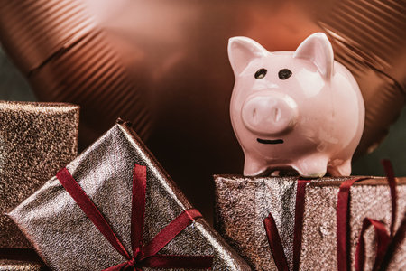 Piggy bank on background of gift boxes on birthday party. Concept saving money, thrift brings joy...