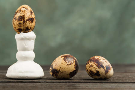Quail eggs in stand on wooden table. Gray background with free space for text. Dietary nutrition presentation of farm products for saleの写真素材