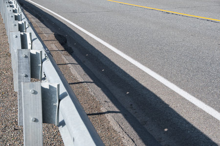 Metal barriers on side of asphalt road. Ensuring traffic safety on highway with marking lines