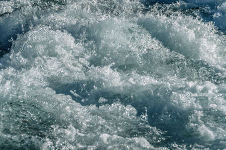 Turquoise ocean waves as backdrop. Sea water boils and foams during surf. Mountain blue river with fast currentの写真素材
