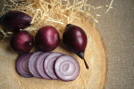 red onions on a wooden boardの写真素材