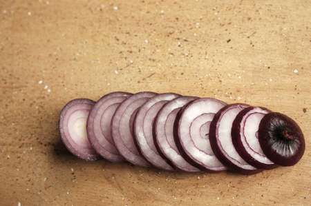 Red onions on a wooden board. cut into rings.の写真素材