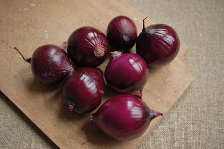 red onions on a wooden boardの写真素材