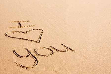 The words "I love you" written in the sandの写真素材