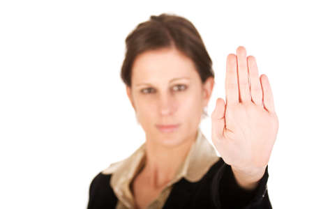 Brunette business woman holding hand up, looking annoyed. Hand in focus, face out of focus.の写真素材