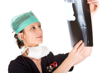 Young attractive Caucausian female health care worker examining an x-ray of a human knee. Isolated on white backgroundの写真素材
