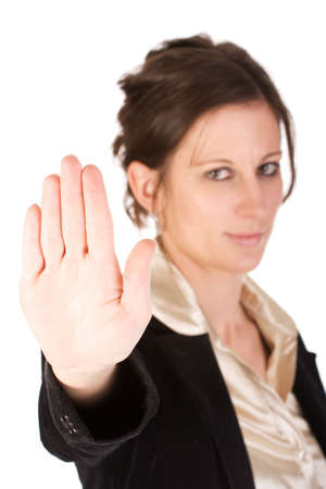 Brunette business woman holding hand up, looking annoyed. Hand in focus, face out of focus.の写真素材