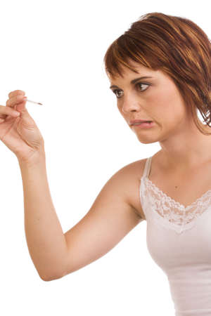 Young female Caucasian adult measuring her body temperature using a fever pen and looking worriedの写真素材
