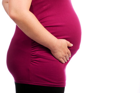 Young pregnant Caucasian woman holding her tummy