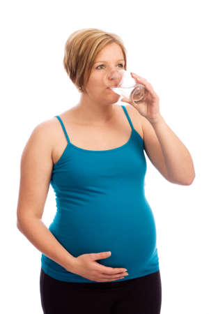 Healthy pregnant Caucasian woman drinking water out of a glassの写真素材