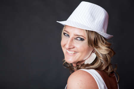 Smiling young Caucasian woman wearing a pinstrip white hatの写真素材