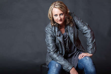 Attractive young blonde woman with attitude looking at camera in studioの写真素材