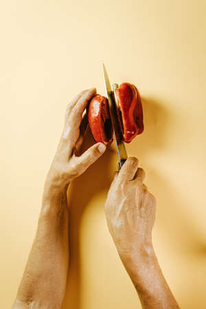 Old woman hands cutting a pepperの写真素材