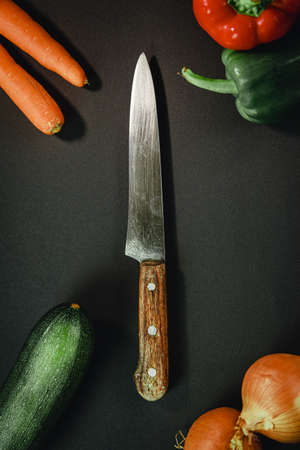 Long knife surrounded by different vegetablesの写真素材