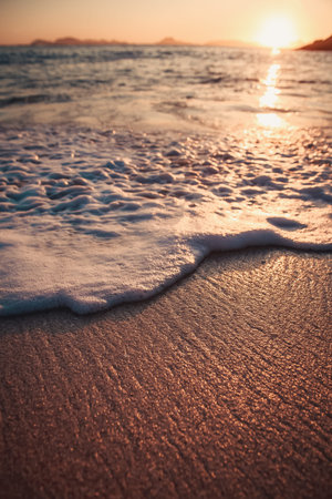 Single tide over the textured sand of the beach