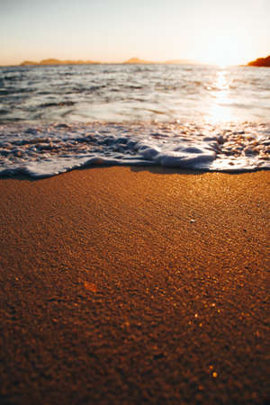 Colorful and bright tide over the golden sandの写真素材