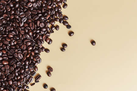 A background composed half of coffee grains and a yellow backgroundの写真素材