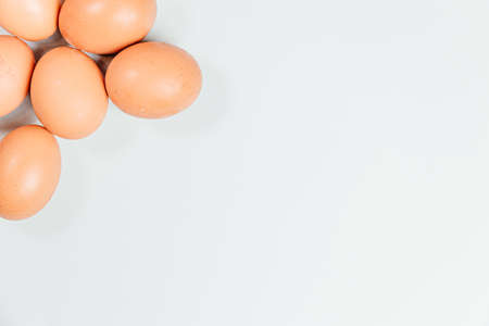 A white background with eggs poking out from one cornerの写真素材