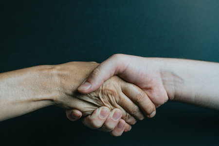 Old and young hand shaking hands