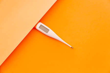 A thermometer over a minimal orange backgroundの写真素材