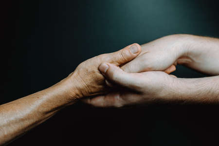 Young hands caressing hands of an old womanの写真素材