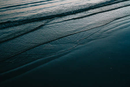 The waves of the sea entering the beach on blue tonesの写真素材