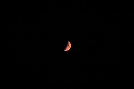 Red moon over a full black backgroundの写真素材