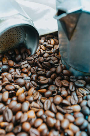 Close up of a lot of coffee grains with an open pot nearbyの写真素材