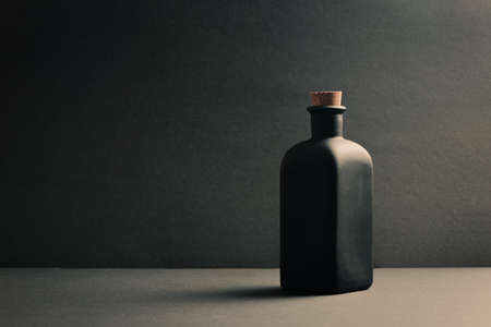 A single black ceramic bottle over a dark backgroundの写真素材