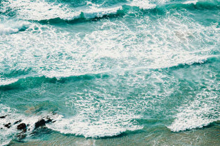 An horizontal aerial view of the waves on a crystal water beachの写真素材