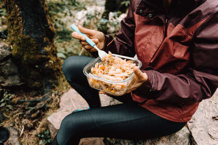 Female hiker eating in the forestの写真素材