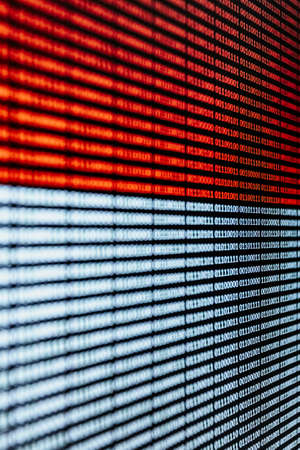 A red and white binary language over a screen backgroundの写真素材