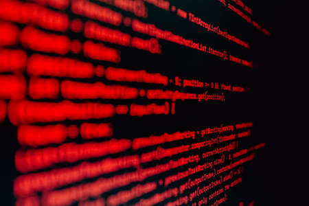 An horizontal background of some code written in red over blackの写真素材