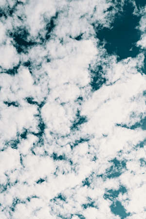 A background made of clean white clouds over a deep blue skyの写真素材