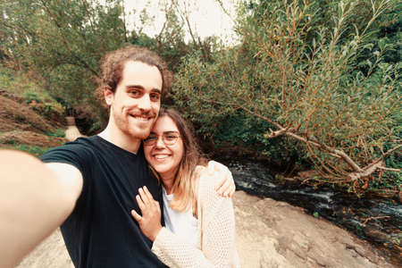 A young couple taking a selfie near a river in Spainの写真素材