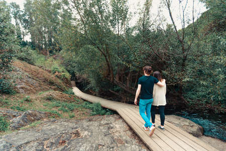 A young couple having a walk by near the river in the forestの写真素材