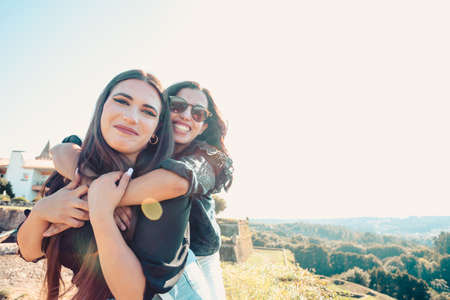 A front view of a couple of women smiling to camera while hugging each other with copy spaceの写真素材