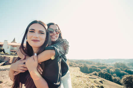 A front view of a couple of women smiling to camera while hugging each other with copy spaceの写真素材